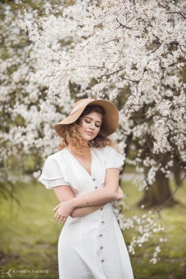 zdjecia  fotograf klaudia-harwig portfolio portret wiosenne-sesje-zdjeciowe kobieta-i-kwiaty paki-na-drzewach kapelusz